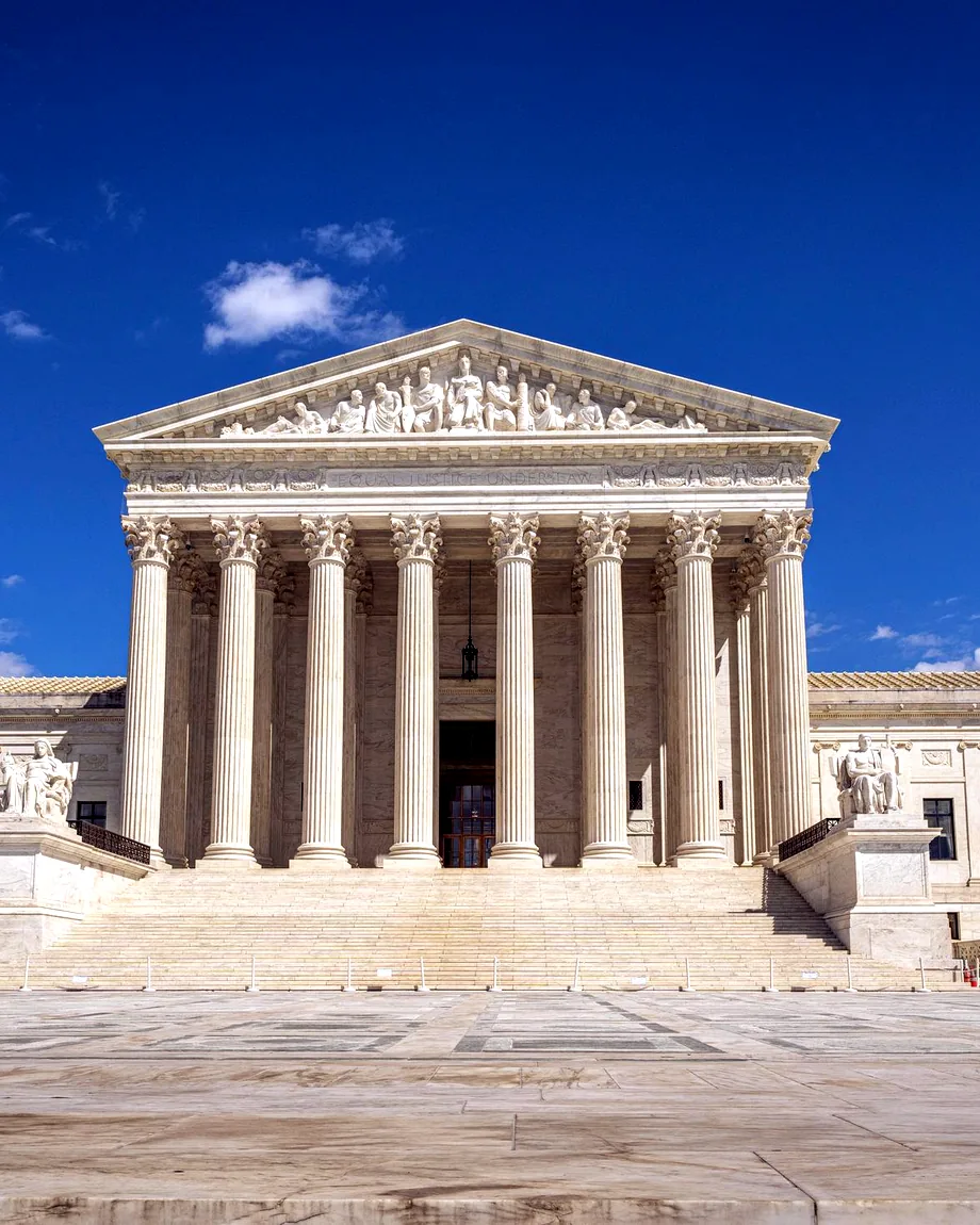 A grand columned institutional building under a clear sky